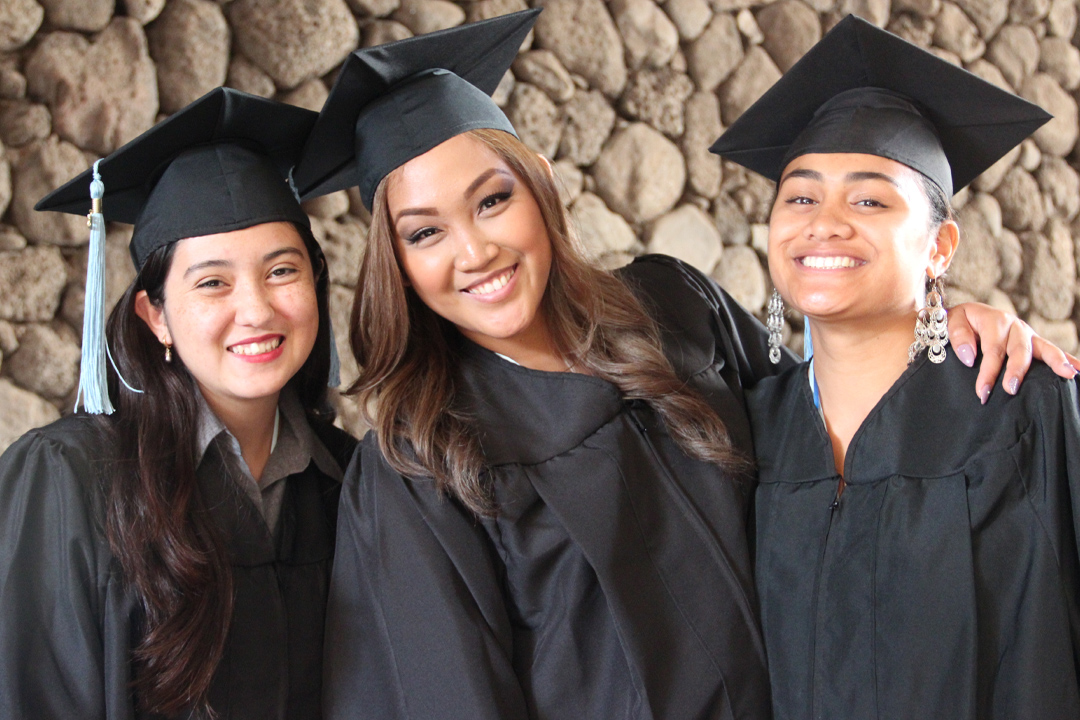 three female graduates in cap and gown