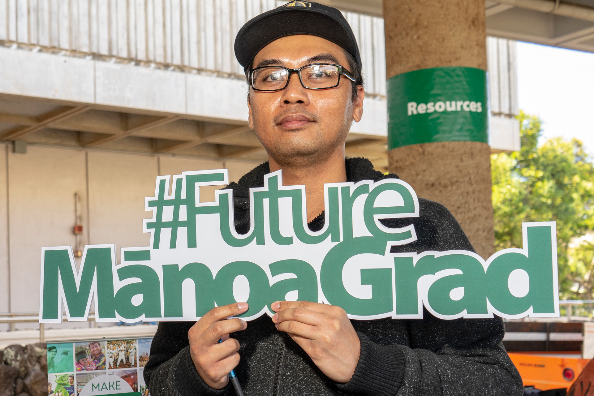male student holding sign with "#futuremanoagrad"