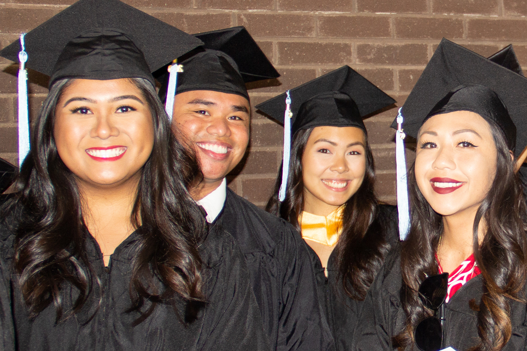 Leeward grads at commencement posing for camera